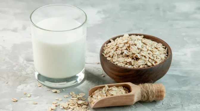 Top view glass cup filled with milk oats inside outside brown pot white background